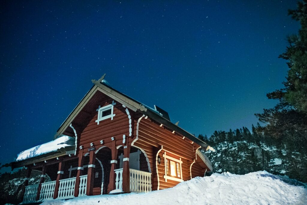 low angle photography of wooden house surrounded with snow